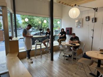 Cast and crew members of 'Rivers Edge' take a brief break while filming in Zoot Coffee in Camden. (Courtesy photo) 4 people in a coffee shop, 3 sitting and 1 wearing an apron, look off camera